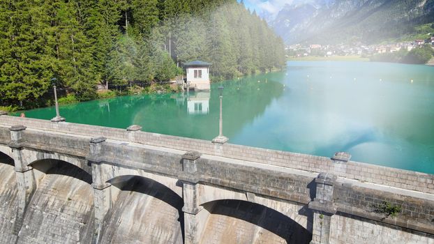 Alpin lake and dam in summertime, view from drone, Auronzo, italian dolomites.