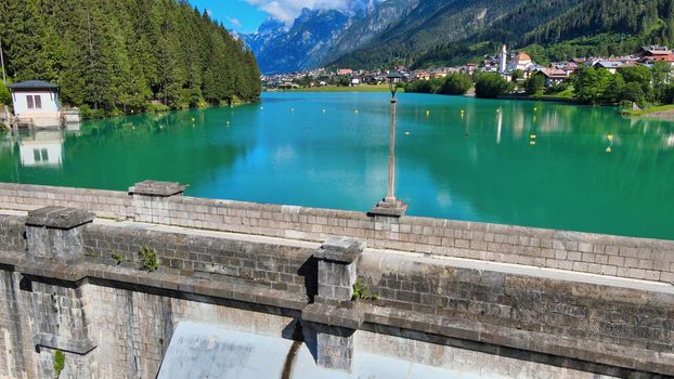 Alpin lake and dam in summertime, view from drone, Auronzo, italian dolomites.