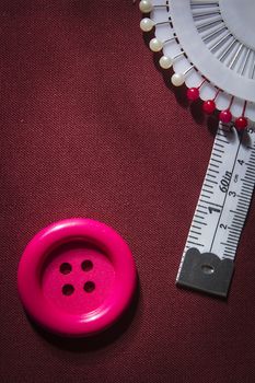 Button and tailor meter on fabric background