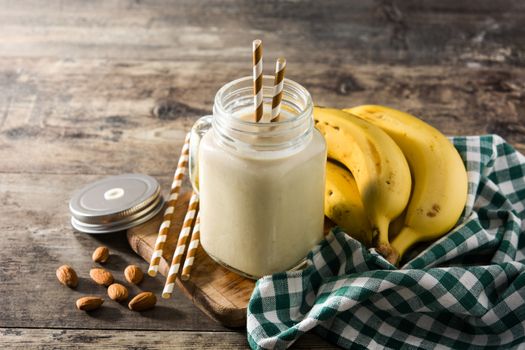 Banana smoothie with almond in jar on wooden table
