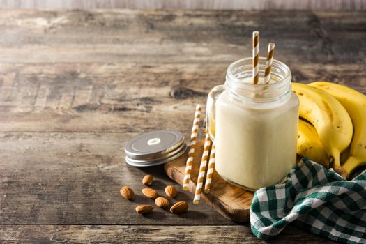 Banana smoothie with almond in jar on wooden table