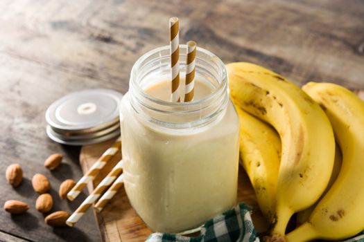 Banana smoothie with almond in jar on wooden table
