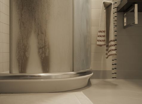 Sexy naked woman's legs inside the shower cabin closes the fogged glass door in her modern design bathroom