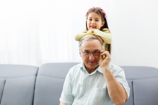 Funny lifestyle portrait of grandchild embracing grandfather