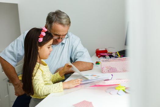 grandfather and granddaughter doing homework