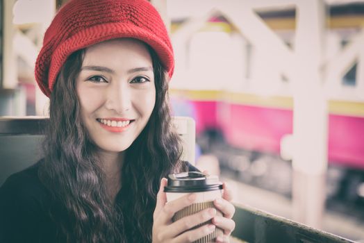 Asian woman traveler has drinking a cup of coffee with traveling by train at Hua Lamphong station at Bangkok, Thailand.