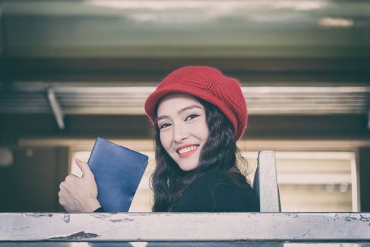 Asian woman traveler has reading a book in the train with happiness at Hua Lamphong station at Bangkok, Thailand.