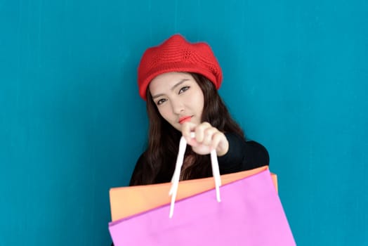 Asian portrait girl has happy and smiling with shopping colorful bags and isolated on green background.