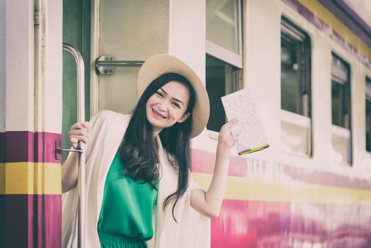 Asian woman traveler has get in the train with happiness at Hua Lamphong station at Bangkok, Thailand.