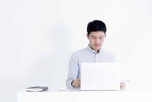 Asian employee man sitting at desk and working with copy space, isolated on white background.