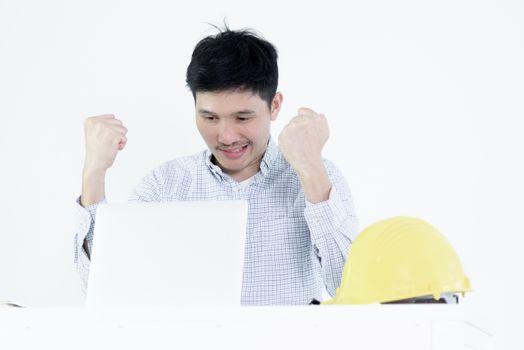 Asian employee engineer salary man sitting at desk and working with feeling successful and victory, isolated on white background.