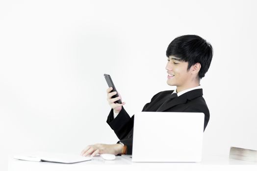 Asian manager businessman sitting at desk and using with phone, isolated on white background.