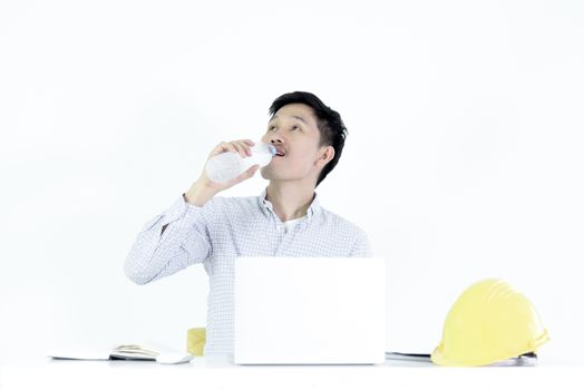 Asian employee engineer salary man sitting at desk and drinking water, isolated on white background.