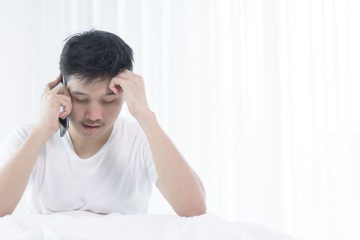 Asian man has wake up with talking about job before start working on bed in the morning.