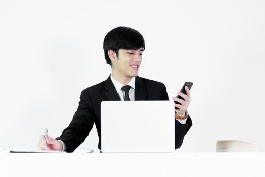 Asian manager businessman sitting at desk and using with phone, isolated on white background.