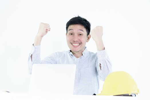 Asian employee engineer salary man sitting at desk and working with feeling successful and victory, isolated on white background.