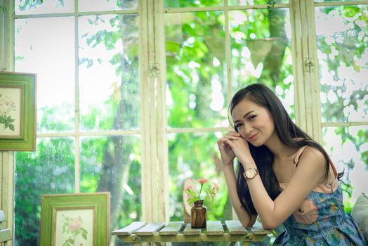 Asian pretty girl has relaxing with happy and smiling at Little Tree Garden cafe, Nakhon Pathom province, Thailand in the morning.