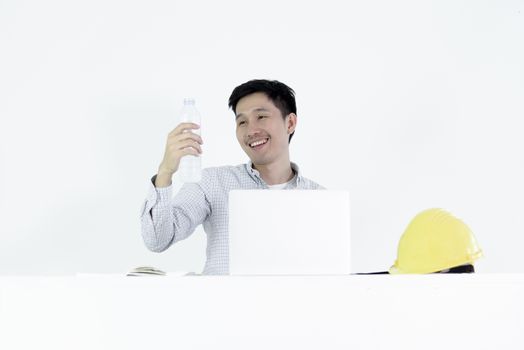 Asian employee engineer salary man sitting at desk and drinking water with happy, isolated on white background.