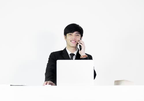 Asian manager businessman sitting at desk and talking with phone, isolated on white background.