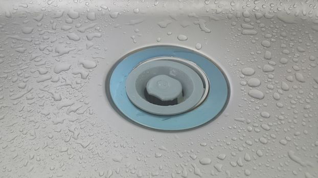 Water drops on grey silver color metallic sink