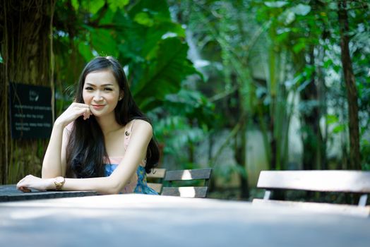 Asian pretty girl has relaxing with happy and smiling at Little Tree Garden cafe, Nakhon Pathom province, Thailand in the morning.