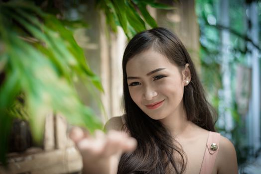 Asian pretty girl has relaxing with happy and smiling at Little Tree Garden cafe, Nakhon Pathom province, Thailand in the morning.