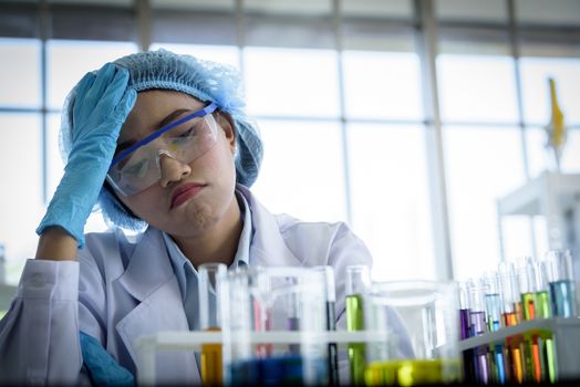 Asian young girl student scientist feeling sad researching  and learning in a laboratory.