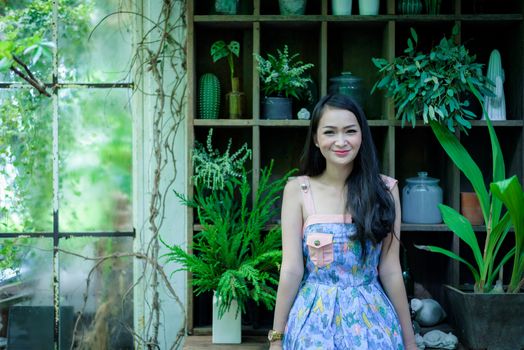 Asian pretty girl has relaxing with happy and smiling at Little Tree Garden cafe, Nakhon Pathom province, Thailand in the morning.