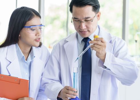 Asian senior laboratory scientist man working at lab with asian young student scientist backgroud.