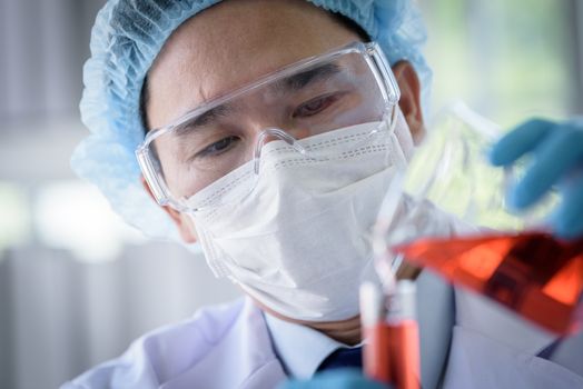 Asian man scientist researching  and learning in a laboratory.