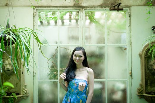 Asian pretty girl has relaxing with happy and smiling at Little Tree Garden cafe, Nakhon Pathom province, Thailand in the morning.