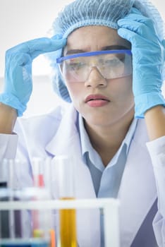 Asian young girl student scientist feeling sad researching  and learning in a laboratory.