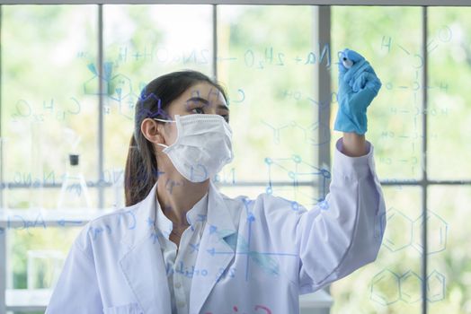 Asian young girl student scientist has writing and researching in laboratory.