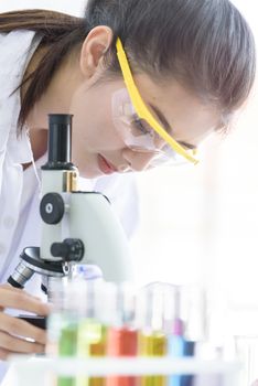 Asian young student scientist researching with a microscope in a laboratory.