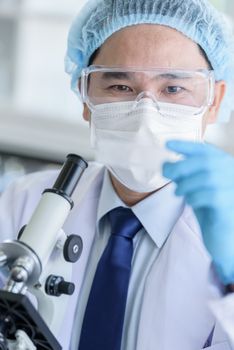 Asian man scientist researching  and learning in a laboratory.