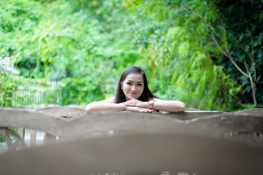 Asian pretty girl has sitting with happy and relaxing at Little Tree Garden cafe, Nakhon Pathom province, Thailand in the morning.