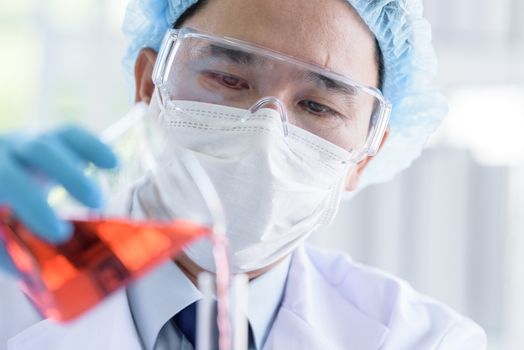 Asian man scientist researching  and learning in a laboratory.