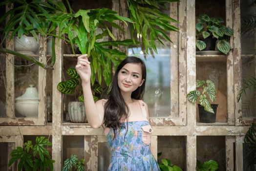 Asian pretty girl has relaxing with happy and smiling at Little Tree Garden cafe, Nakhon Pathom province, Thailand in the morning.