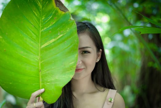 Asian pretty girl has closing right eye with close up concept at Little Tree Garden cafe, Nakhon Pathom province, Thailand in the morning.