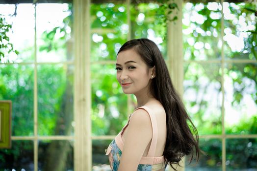 Asian pretty girl has relaxing with happy and smiling at Little Tree Garden cafe, Nakhon Pathom province, Thailand in the morning.