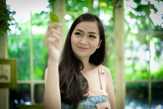 Asian pretty girl has relaxing with happy and smiling at Little Tree Garden cafe, Nakhon Pathom province, Thailand in the morning.