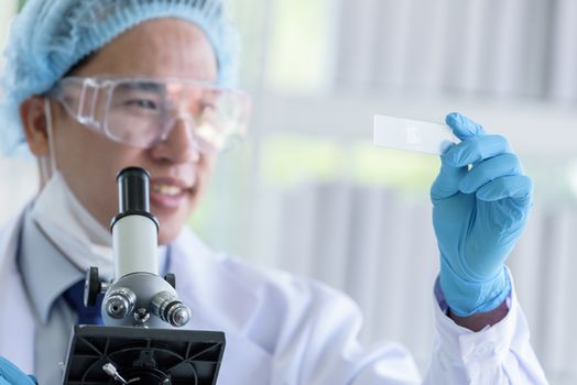 Asian man scientist researching  and learning in a laboratory.