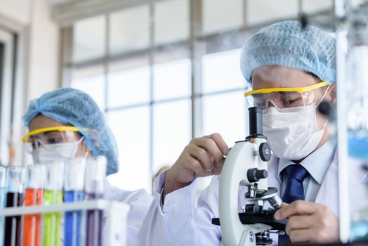 Asian senior scientist have teaching young student scientist in a laboratory.