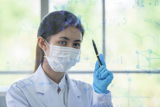 Asian young girl student scientist has writing and researching in laboratory.