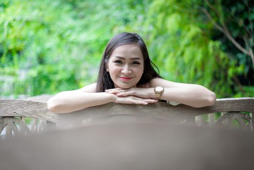 Asian pretty girl has sitting with happy and relaxing at Little Tree Garden cafe, Nakhon Pathom province, Thailand in the morning.