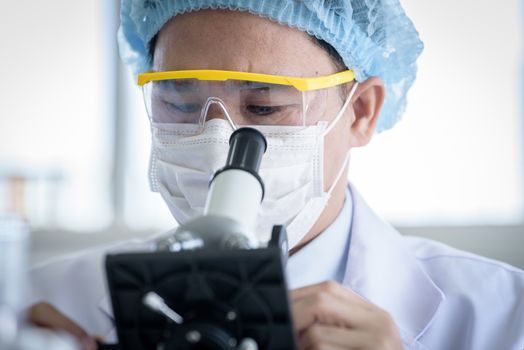 Asian young man student scientist researching  and learning in a laboratory.