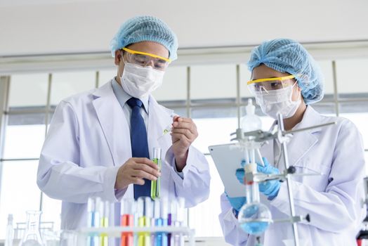 Asian senior scientist have teaching young student scientist in a laboratory.