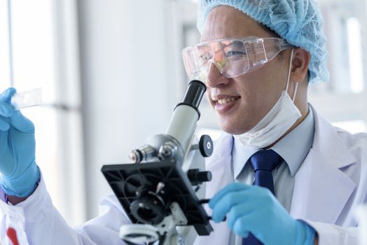 Asian man scientist researching  and learning in a laboratory.