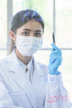 Asian young girl student scientist has writing and researching in laboratory.