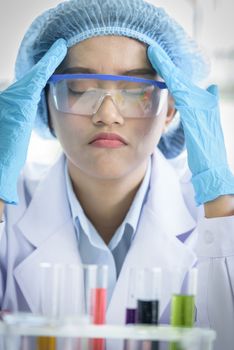 Asian young girl student scientist feeling sad researching  and learning in a laboratory.